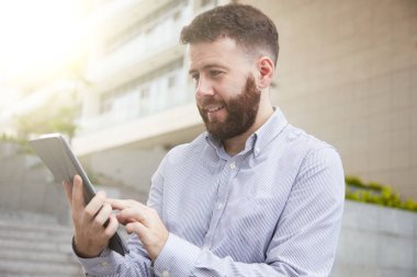 Tablet bilgisayarda okuma makale genç girişimci gülümseyen