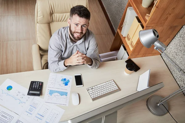 Jovem Empreendedor Sorridente Sentado Sua Mesa Escritório Olhando Para Câmera — Fotografia de Stock