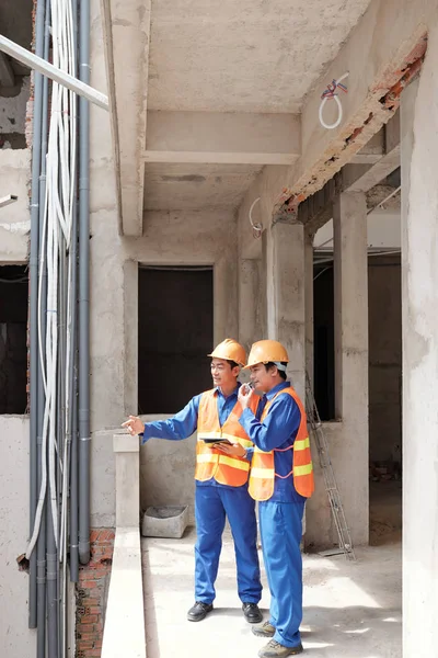 Civil engineers discussing problem with communications installation on construction site