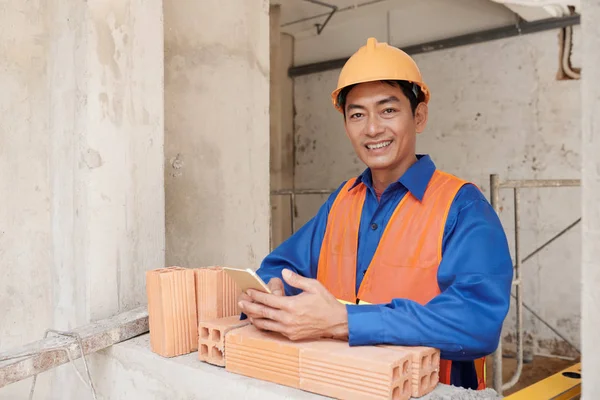 Fröhlicher Vietnamesischer Bauarbeiter Verbringt Kurze Pause Mit Smartphone Der Hand — Stockfoto