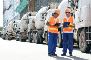 Beton karıştırıcı satırında ayakta ve yaklaşan iş tartışırken Asya Oluşturucu