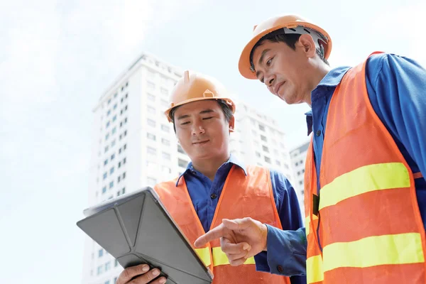 Lächelnde Vietnamesische Arbeiter Auf Der Baustelle Diskutieren Projekt Tablet Computer — Stockfoto