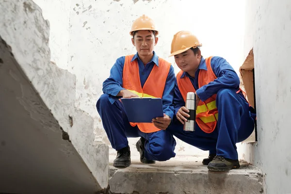 越南建筑工人在楼梯上短暂休息 讨论工作计划 — 图库照片