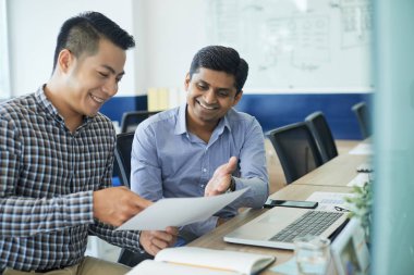 Belge Office iş toplantısında tartışırken neşeli çok etnik gruptan oluşan iş arkadaşları