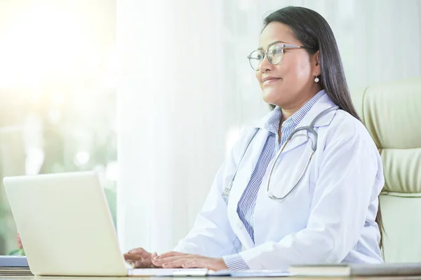 Vrolijke Aziatische Vrouw Arts Vacht Zit Aan Bureau Met Laptop — Stockfoto