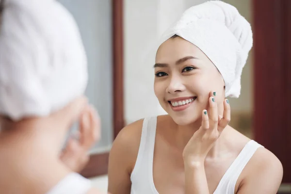 迷人的亚洲女人在白色毛巾触摸纯净柔软的皮肤看着镜子反射 — 图库照片