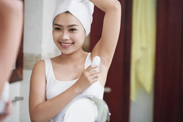 Cheerful Asian Woman Towel Applying Deodorant Armpits Standing Front Mirror — Stockfoto