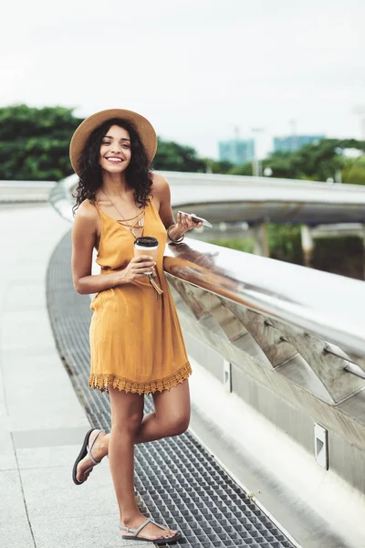 愉快有吸引力的亚洲妇女站立在桥上和喝外卖咖啡 — 图库照片