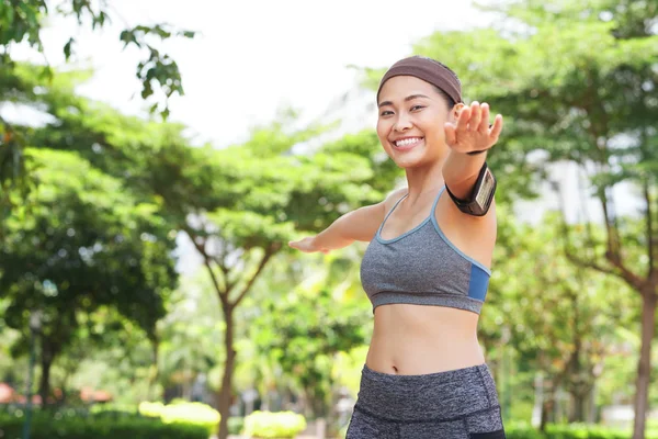 年轻快乐的亚洲女子穿着运动服和袖标 双手分开 在夏季公园训练 — 图库照片