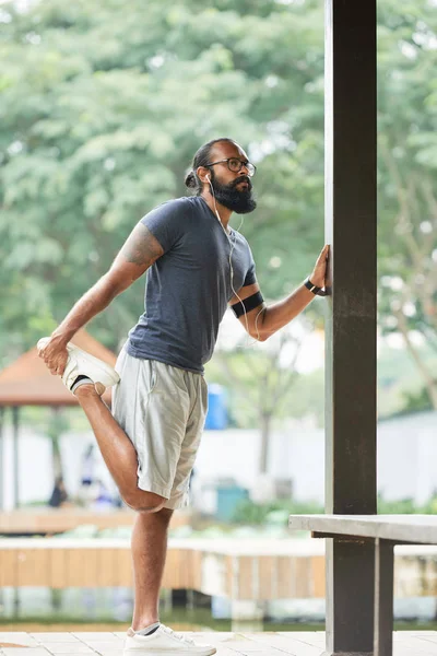 Athletic Man Beard Tattooed Hand Doing Stretching Exercise Listening Music — Stockfoto