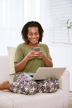 Oldukça neşeli genç siyah kadın manifatura onun laptop dizüstü bilgisayar ile