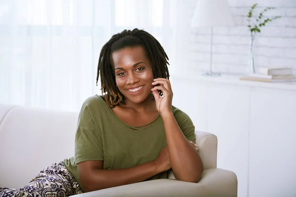 自宅のソファーで休んで若いアフリカ系アメリカ人の笑顔の女性の肖像画 — ストック写真