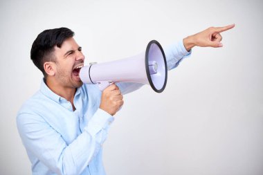 Portrait of a man yelling into a megaphone and pointing the direction against white background