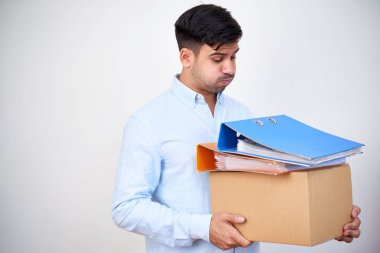 Holding ve karton kutu ve büyük klasörler üzerinde bakarak genç işadamı onda çok iş