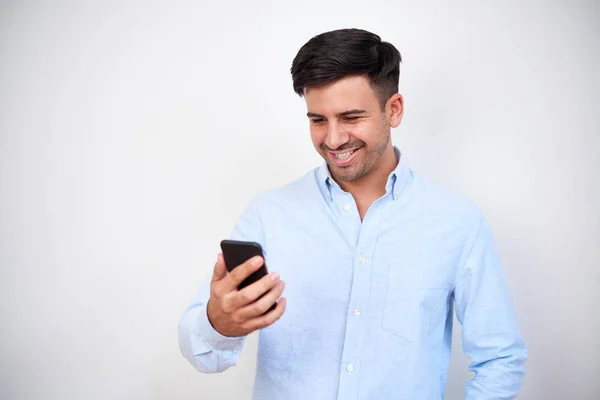 Junger Glücklicher Gutaussehender Mann Blickt Auf Sein Smartphone Und Lächelt — Stockfoto