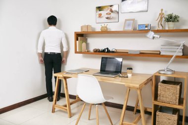 Oda onun İşyeri Ofis, onun çalışmalarını suçlu yakınındaki köşesinde ayakta işadamı arkadan görünüş