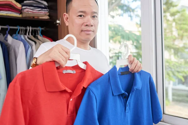 Зрелый Вьетнамский Мужчина Выбирает Цвет Рубашки Поло Сегодня — стоковое фото