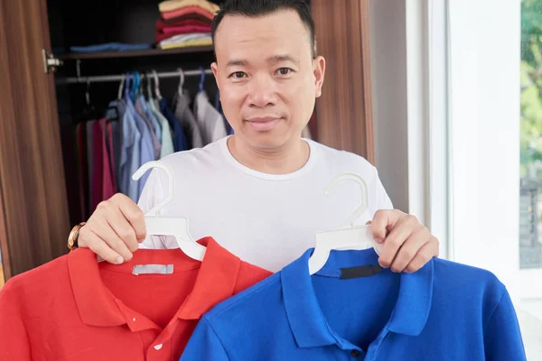 Retrato Homem Asiático Positivo Mostrando Camisas Pólo Azul Vermelho — Fotografia de Stock