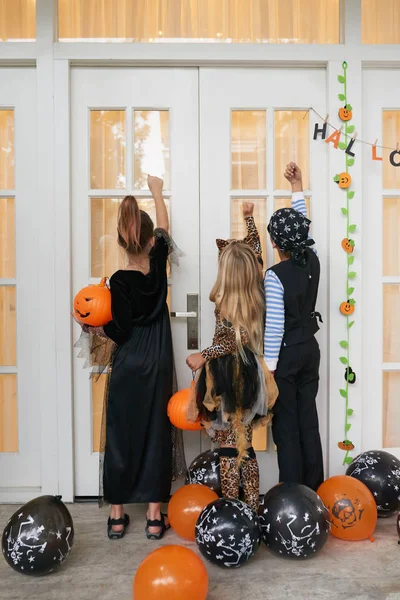 Vista Trasera Los Niños Con Hermosos Disfraces Halloween Pie Porche — Foto de Stock