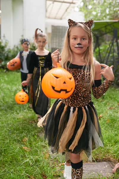 ハロウィーンのスマートの白人の子供の肖像画のカボチャ屋外カメラ目線とラインに立って顔絵画と衣装します — ストック写真