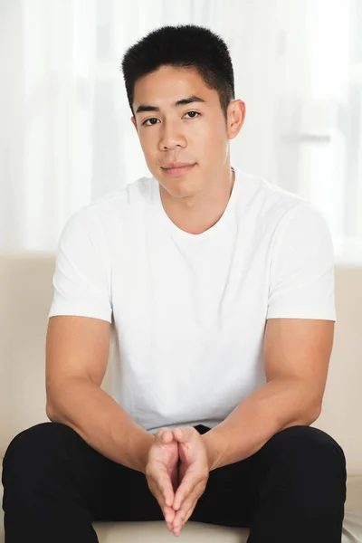 Attractive Unsmiling Mixed Race Man Sitting Couch Looking Camera Stock Picture