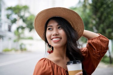 Hasır şapka açık havada eve servis kahve ile duran güzel çekici Asyalı kadın
