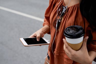 Kahve içme ve mesajlarını smartphone içinde genç kadının resim kırpılmış