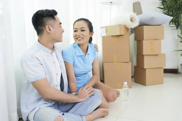 Happy Ethnic Couple Embracing While Sitting Floor Spacious Apartment Boxes — Stock Photo, Image