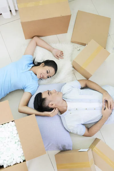 上記のアジア人男性と恋を移動しながらボックスの中で床の上に横たわる女性のショット — ストック写真