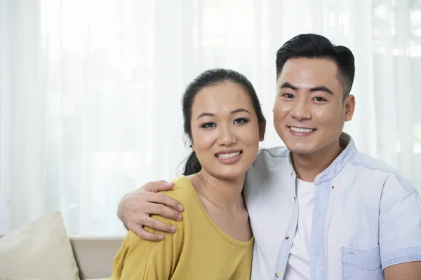 Young Asian Woman Man Embracing Home Smiling Camera — Stok fotoğraf