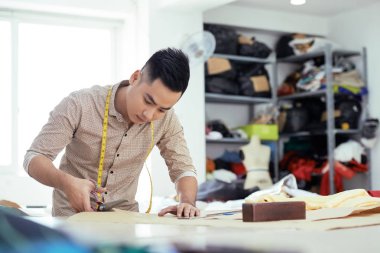 Bir terzi çalışma ve atelier eserlerindeki makas kullanılarak genç adam 