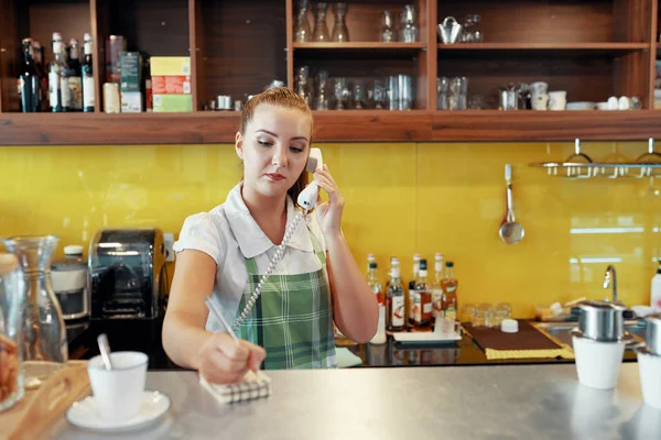 Jovem Mulher Avental Falando Telefone Enquanto Estava Balcão Café Escrevendo — Fotografia de Stock