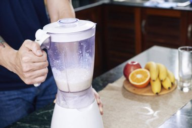 Protein içeceği sabah hazırlanırken blender kullanan adam