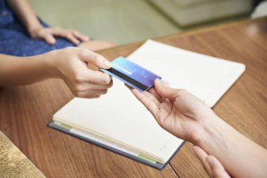 Spa salonu resepsiyonist kontuarında kredi kartı veren Konuk yukarıdan kırpma vurdu
