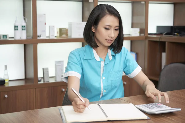 Mujer Bastante Asiática Trabajando Salón Spa Calculando Mientras Toma Notas —  Fotos de Stock