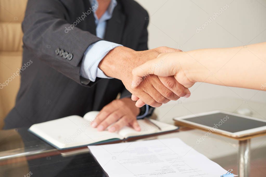 Close-up of businessman concluding a deal with businesswoman after signed the contract