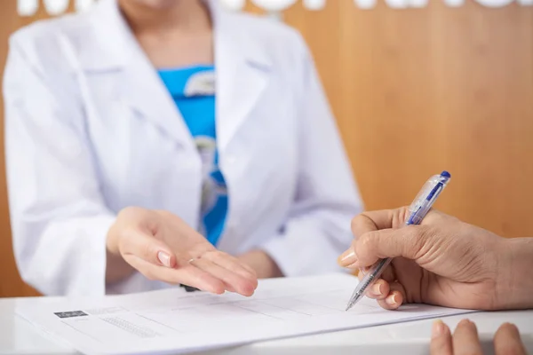 Close Mãos Femininas Preenchendo Documentos Médicos Hospital Com Enfermeira Segundo — Fotografia de Stock