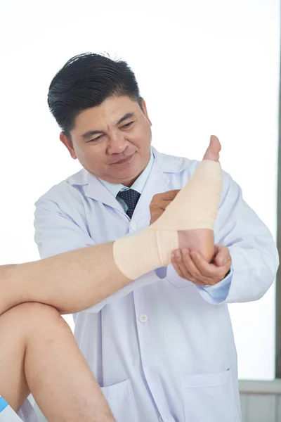 Hombre Asiático Adulto Uniforme Médico Aplicando Vendaje Pie Tobillo Paciente — Foto de Stock