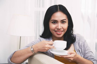 Evde çay çekici Filipino genç kadının portresi