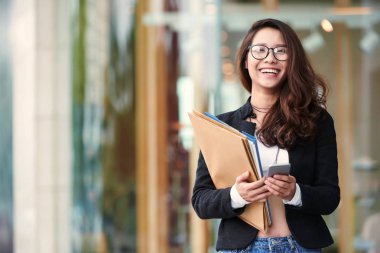 Çok gülen Vietnamca ve kadın ile birçok klasörleri ve belge smartphone