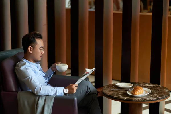 コーヒーを飲むと 毎日新聞を読んで成熟したアジアの実業家 — ストック写真
