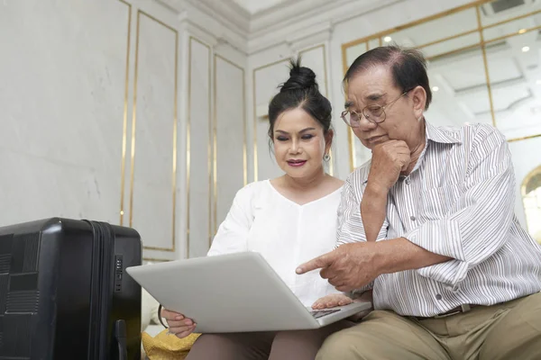 Asiatico Anziani Coppia Con Computer Portatile Concentrato Prenotazione Hotel Camera — Foto Stock