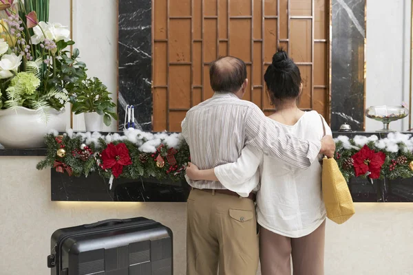 Yaşlı Çift Ayakta Otel Resepsiyonunda Noel Için Dekore Edilmiştir — Stok fotoğraf