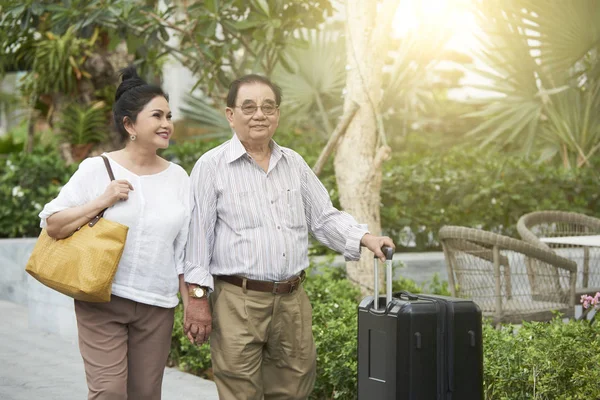 带着手提箱来到度假村的快乐的老年越南夫妇 — 图库照片