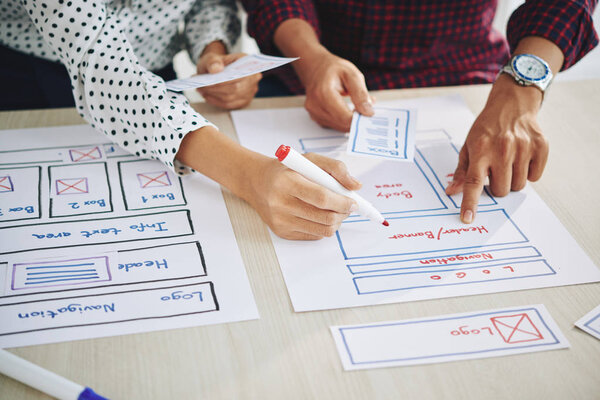 Руки менеджеров проектов, работающих над дизайном интерфейса
