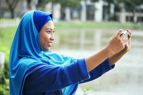 Красивая Индонезийская Женщина Синем Хиджабе Улыбается Делает Селфи Мобильном — стоковое фото