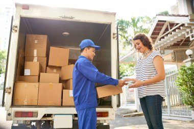 Teslimatçı parsel ve mektup genç kadın için veriyor