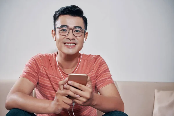 Fröhlicher Junger Mann Der Musik Auf Dem Smartphone Hört — Stockfoto