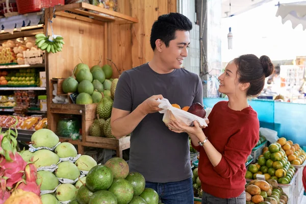 うれしそうな若いアジアのカップル購入新鮮な熟した果物と野菜 — ストック写真