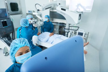 Asya cerrahlar cerrahi tiyatro faaliyet gerçekleştirmek için modern ekipman kullanarak atış yukarıdan